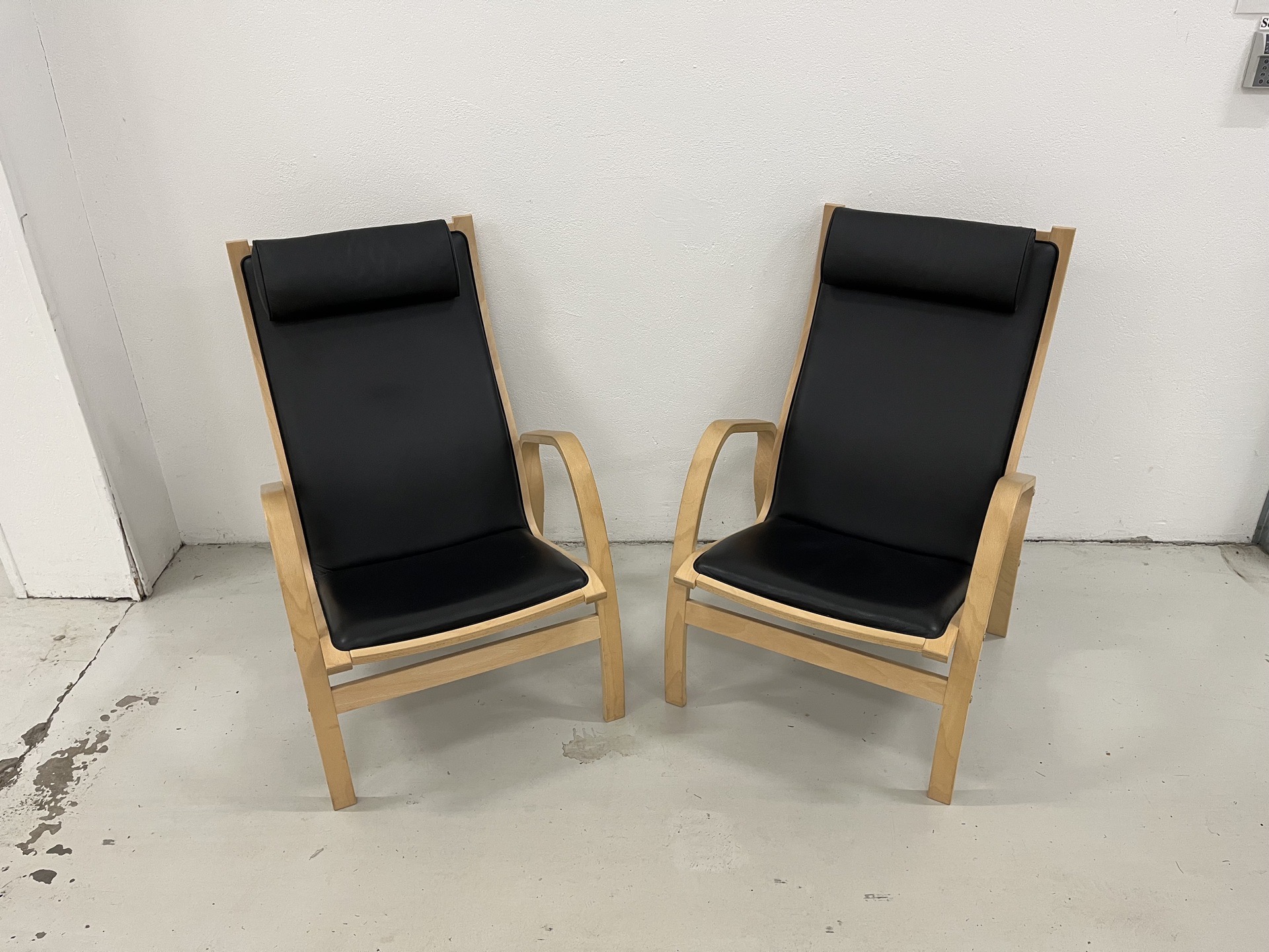 Fin Østergaard lænestole i sort hanskeblød læder og med stel i sæbebehandlet bøg.Pris 7.500,-