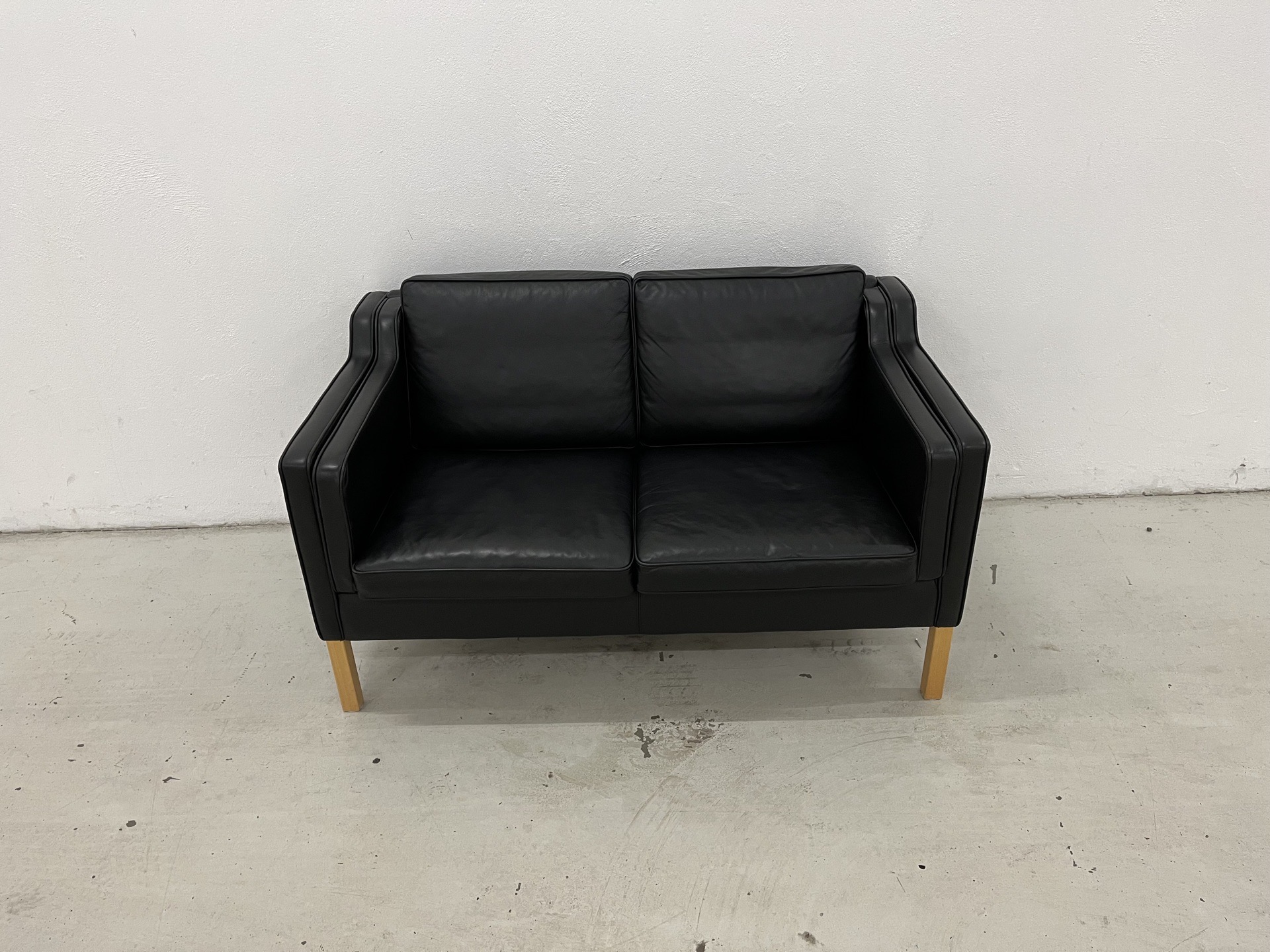 Stouby Eva 2 Pers.Sofa i sort semianilin læder og med ben i Eg. Pris 7.800,-
