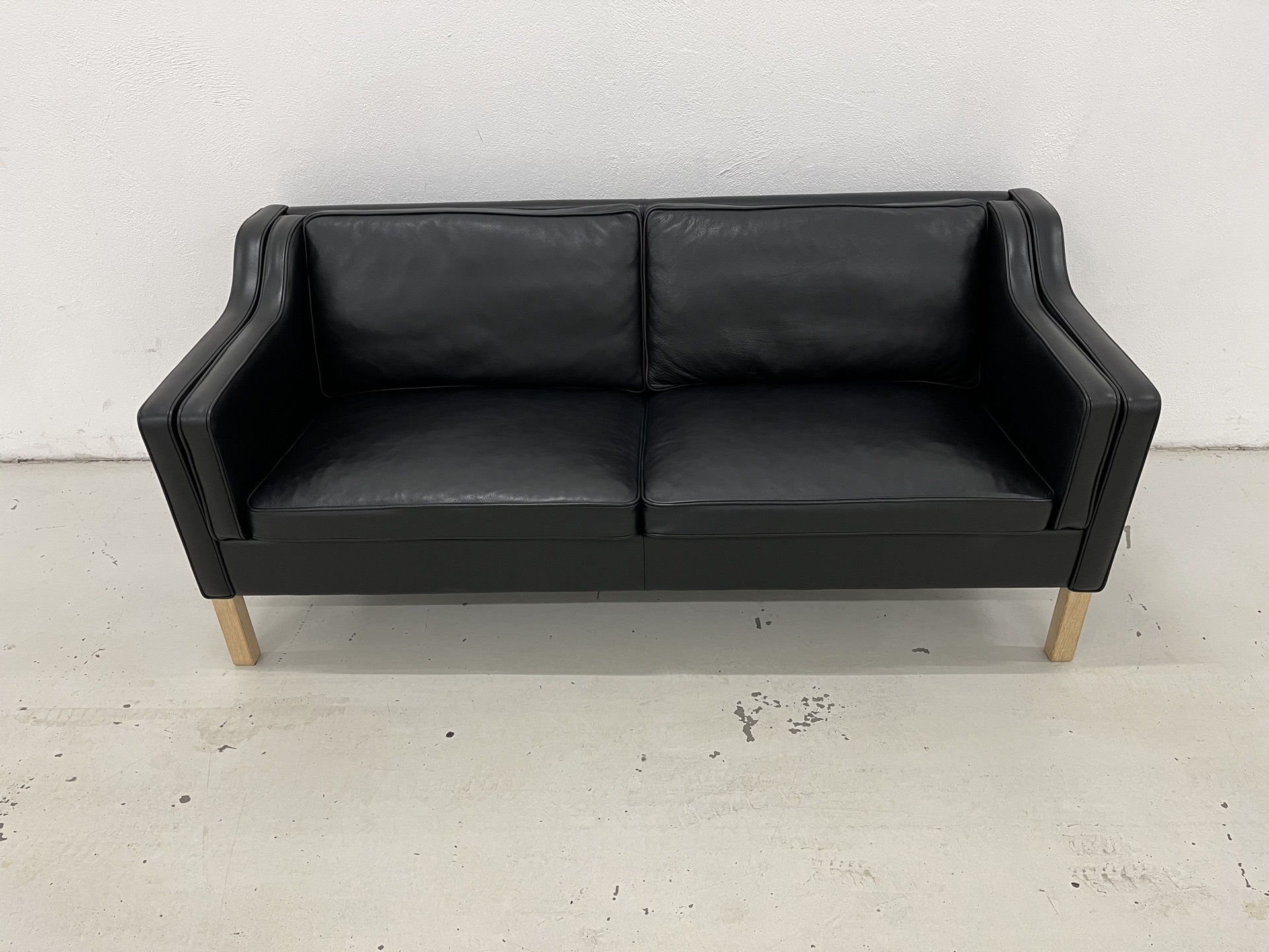 Eksklusiv Mogens Hansen MH195 2,5 Pers. Sofa i sort Odin 18 læder og med ben i sæbe behandlet egetræ. Pris 20.000,-