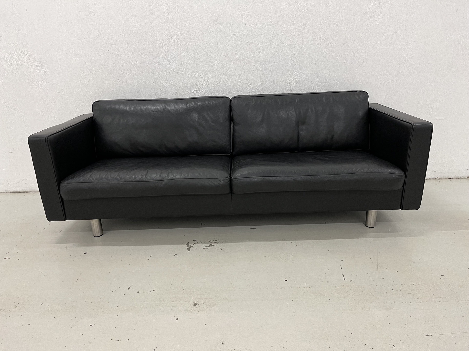 Mogens Hansen MH321 3 Pers. Sofa i sort semianilin læder og med ben i børstet stål. Pris 20.500,-